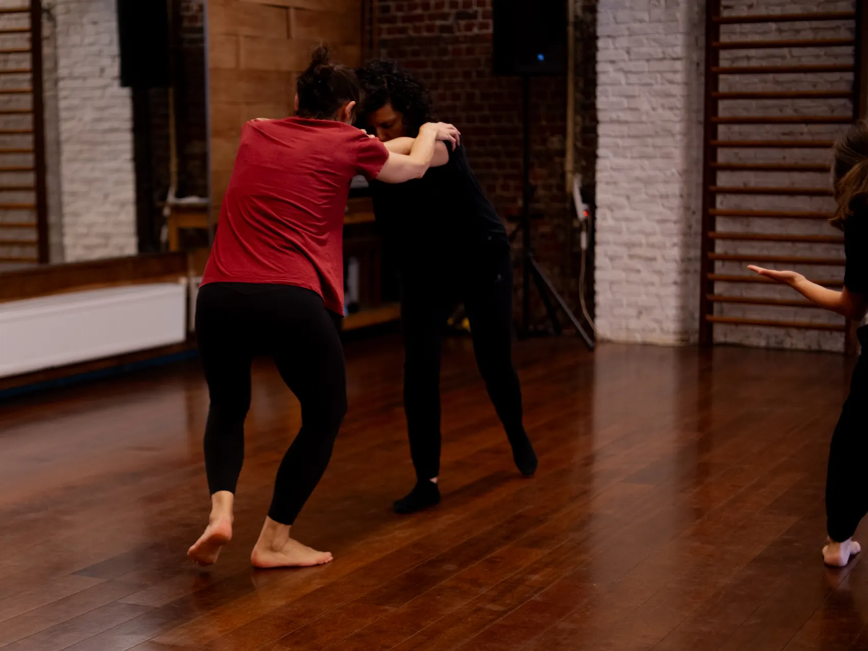 Twee danseressen als duo op de parketvloer van de studio