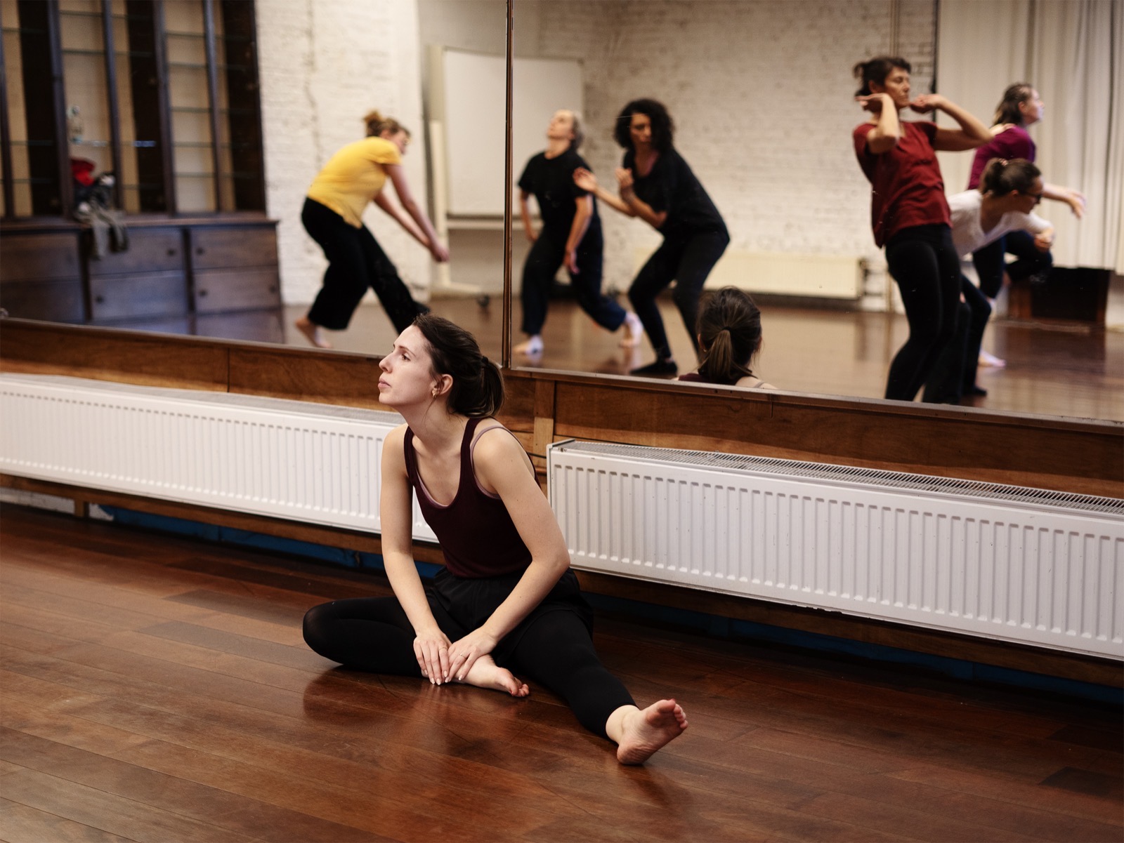 Cours collectif au studio : les élèves dansent devant le miroir pendant que Bettina observe