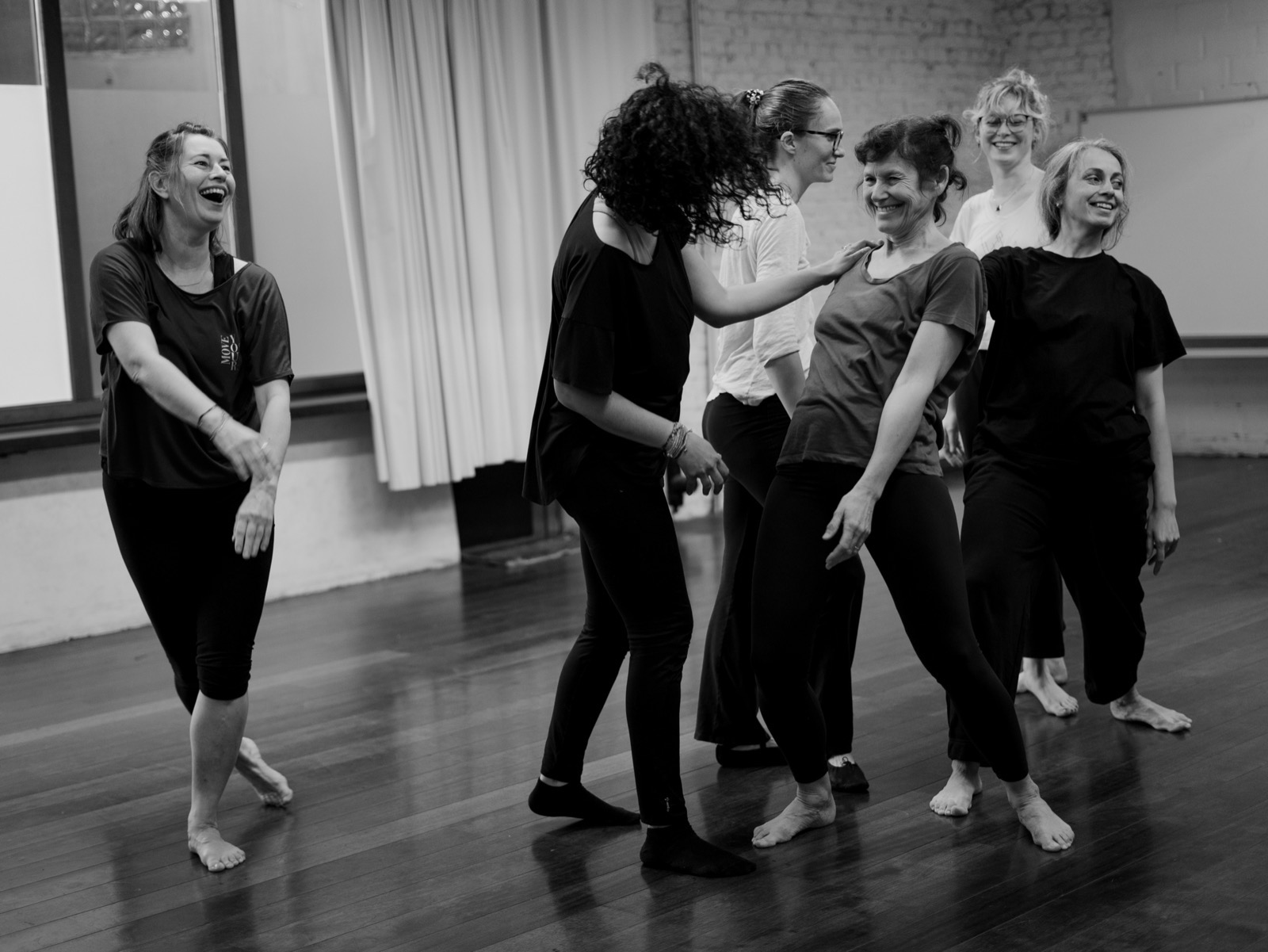 Un groupe d'élèves rit ensemble pendant un cours collectif de Bettina